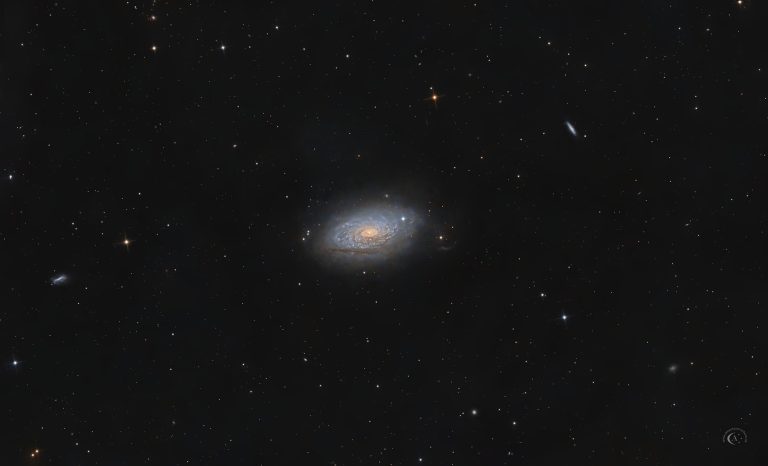 Astrofotografie der flocculenten Spiralgalaxie M63, der Sonnenblumengalaxie, mit hellem Kern, flockigen Spiralarmsegmenten und dunklen Staubstrukturen.