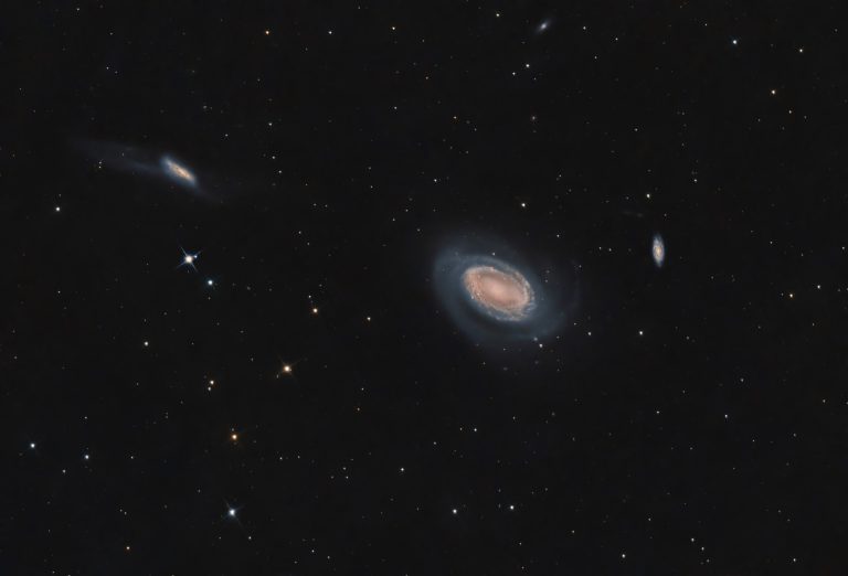 Aufnahme von NGC 4725 mit NGC 4747 und sichtbaren Gezeitenausläufern sowie der weiter entfernten Hintergrundgalaxie NGC 4712.